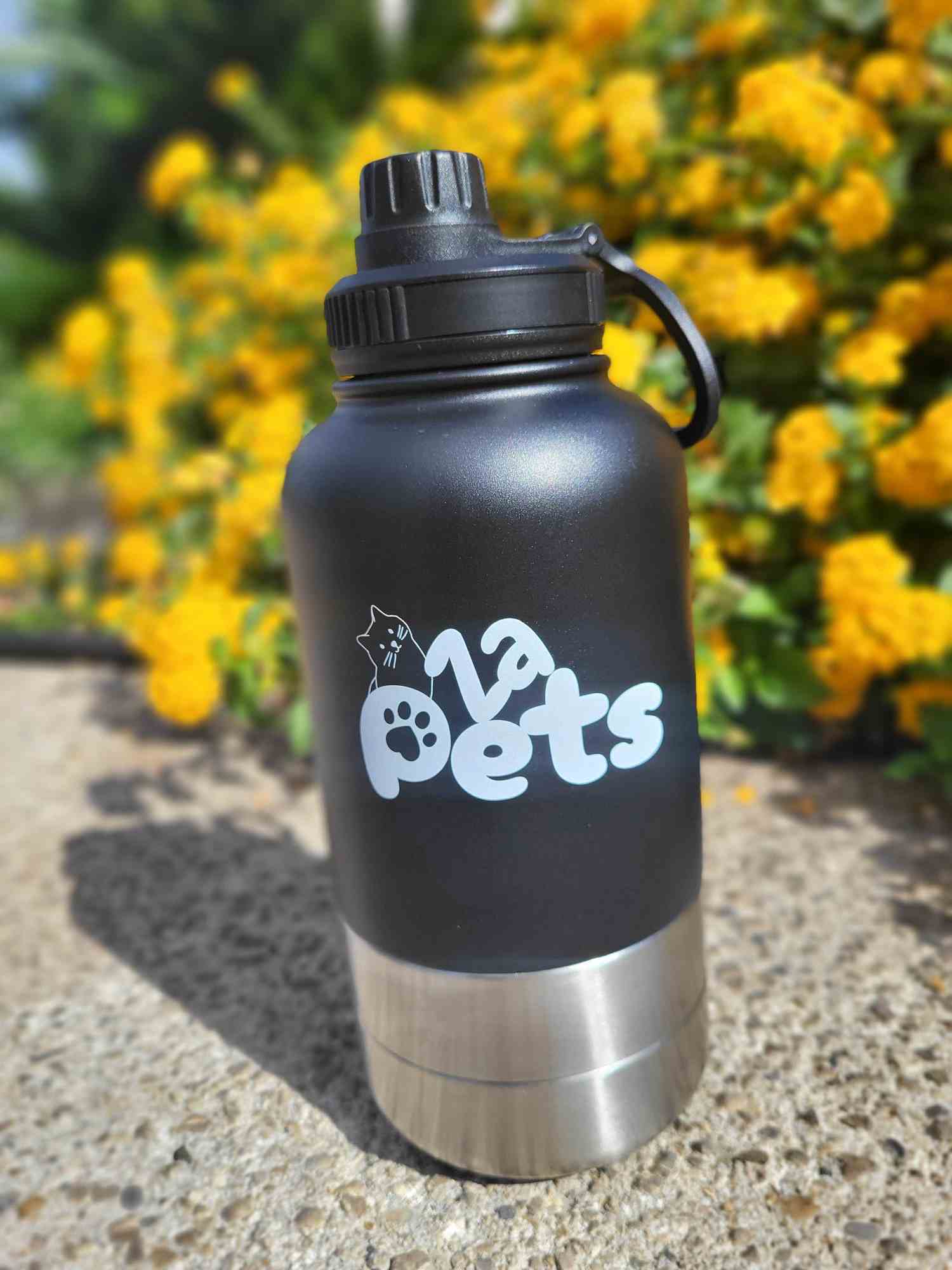 gourde zapets Gourde isotherme Zapets posée devant des fleurs jaunes en extérieur